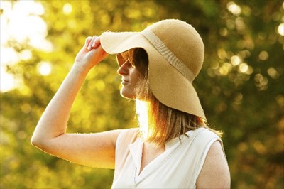 大きなつばの帽子で日焼けを予防する女性